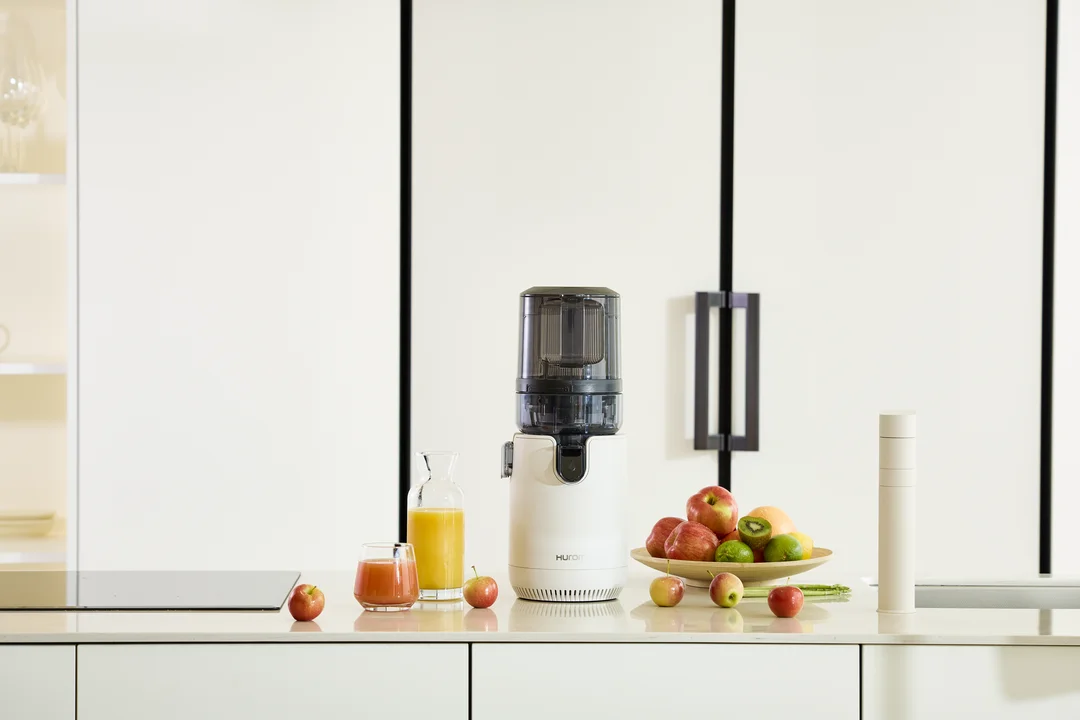 Świeżo wyciśnięty sok obok wyciskarki wolnoobrotowej Hurom E50ST w kuchni