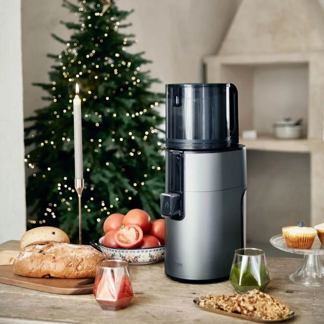 Lifestyle ujęcie wyciskarki Hurom H400 – świeżo wyciśnięty sok i owoce na stole