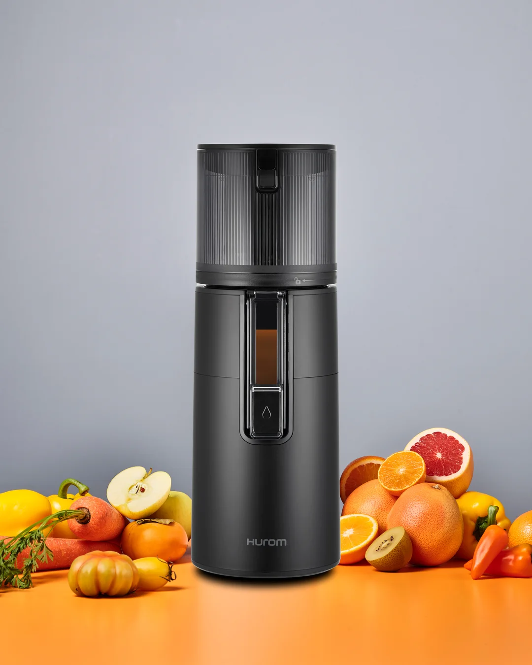 Wyciskarka Hurom H400 – lifestyle ujęcie z owocami i gotowym sokiem na stole