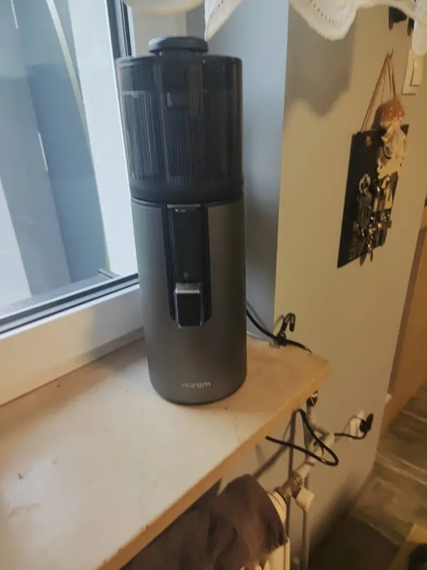 Szara wyciskarka Hurom H400 przy oknie